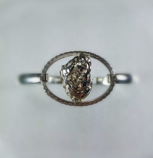 Close-up of a silver ring with an oval-shaped design and intricate detailing.