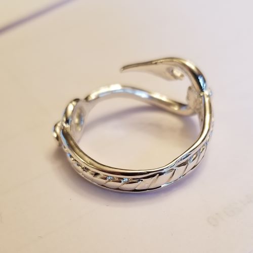 Silver ring shaped like a fish hook with intricate patterns.