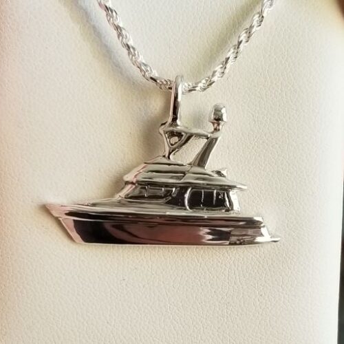 Silver yacht-shaped pendant on a chain necklace.