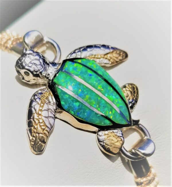 A glass turtle figurine with a green shell and detailed fins.