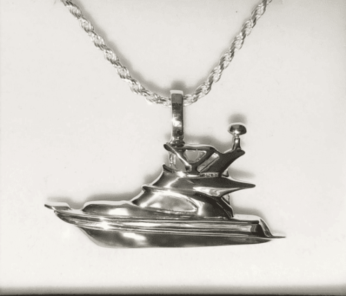Silver pendant shaped like a futuristic spaceship on a chain.