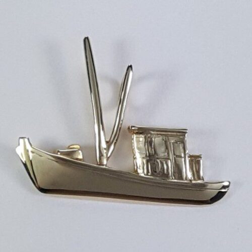 A silver boat-shaped brooch with detailed sails and cabin.