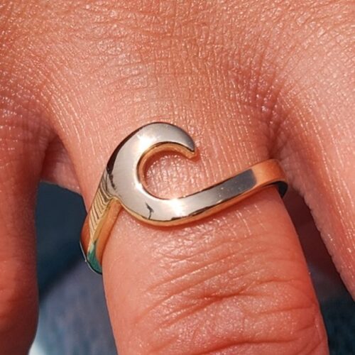 Silver wave-shaped ring on a finger.